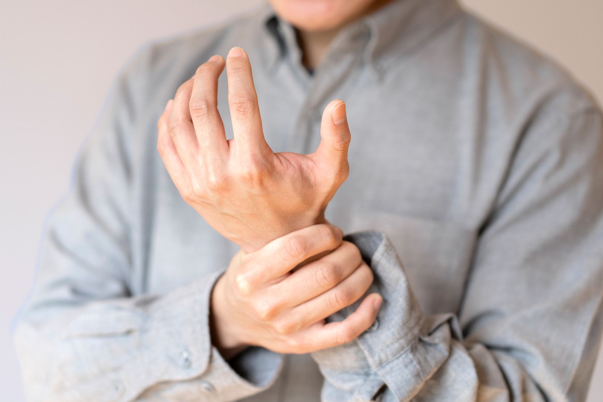 手首を押さえる男性