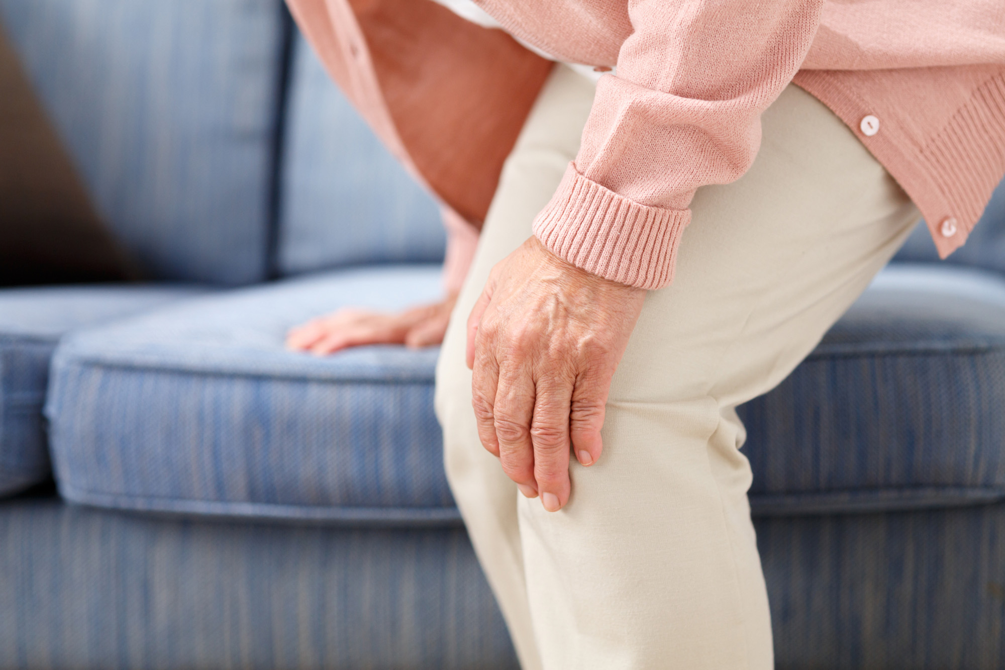 つらそうに膝を押さえる女性