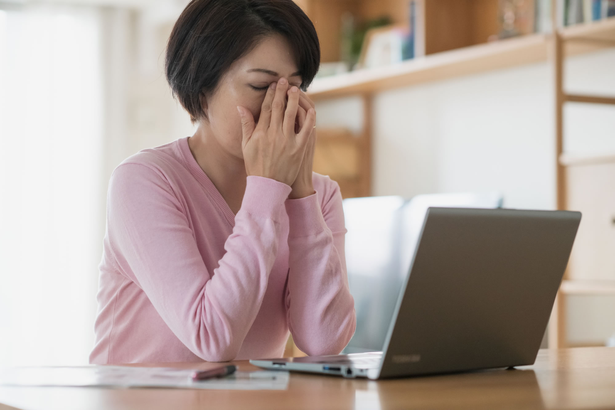 両手で目元を押さえている女性