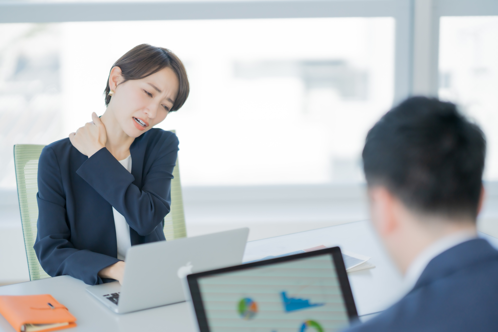 オフィスワークの時に五十肩で悩んでいる女性