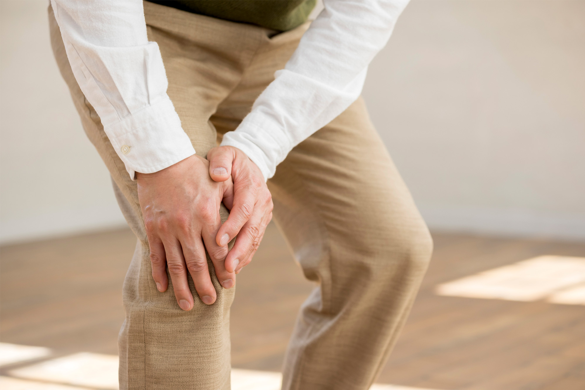 関節痛で膝を押さえている様子
