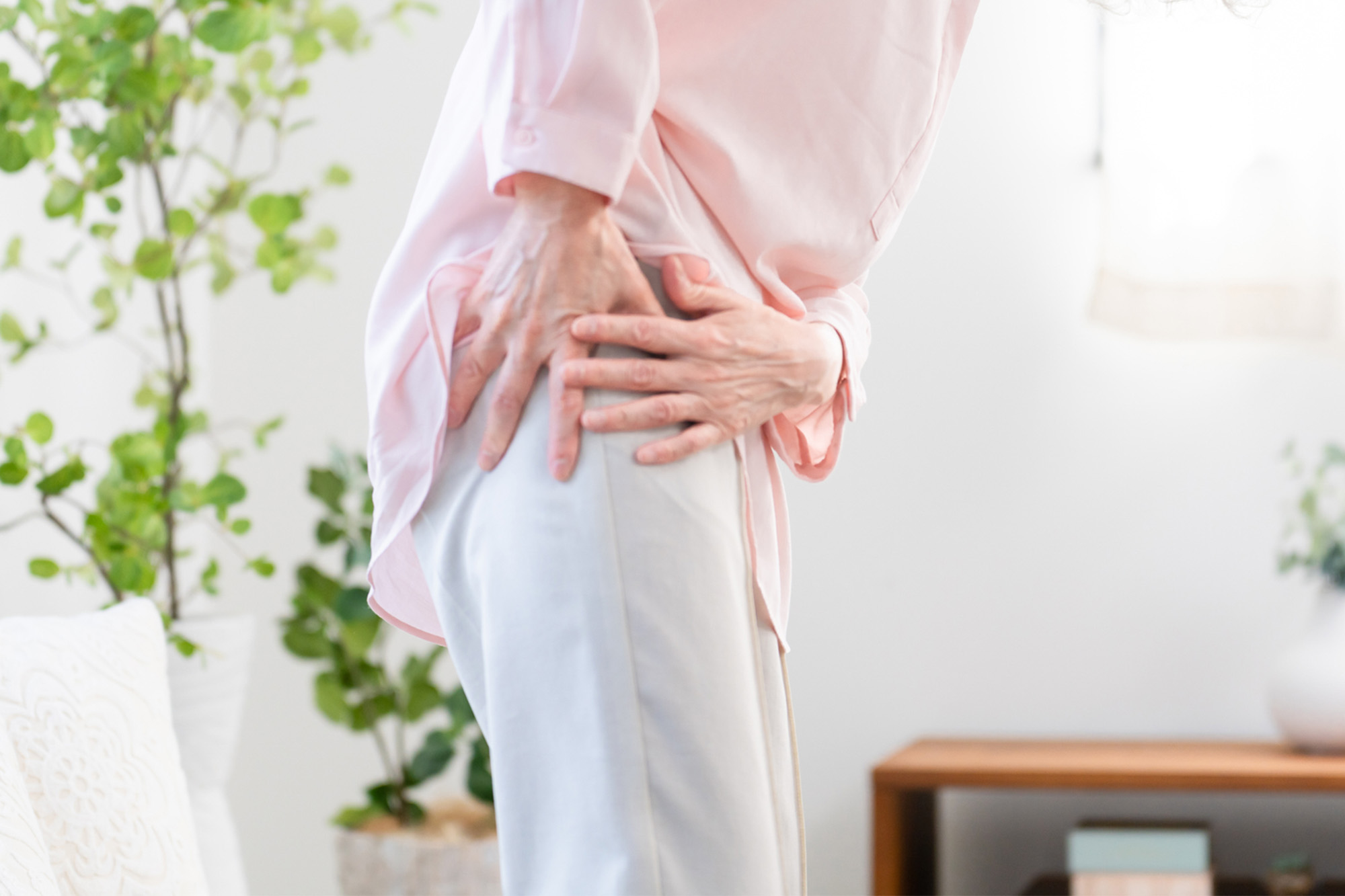 坐骨神経の痛みで坐骨を押さえる女性