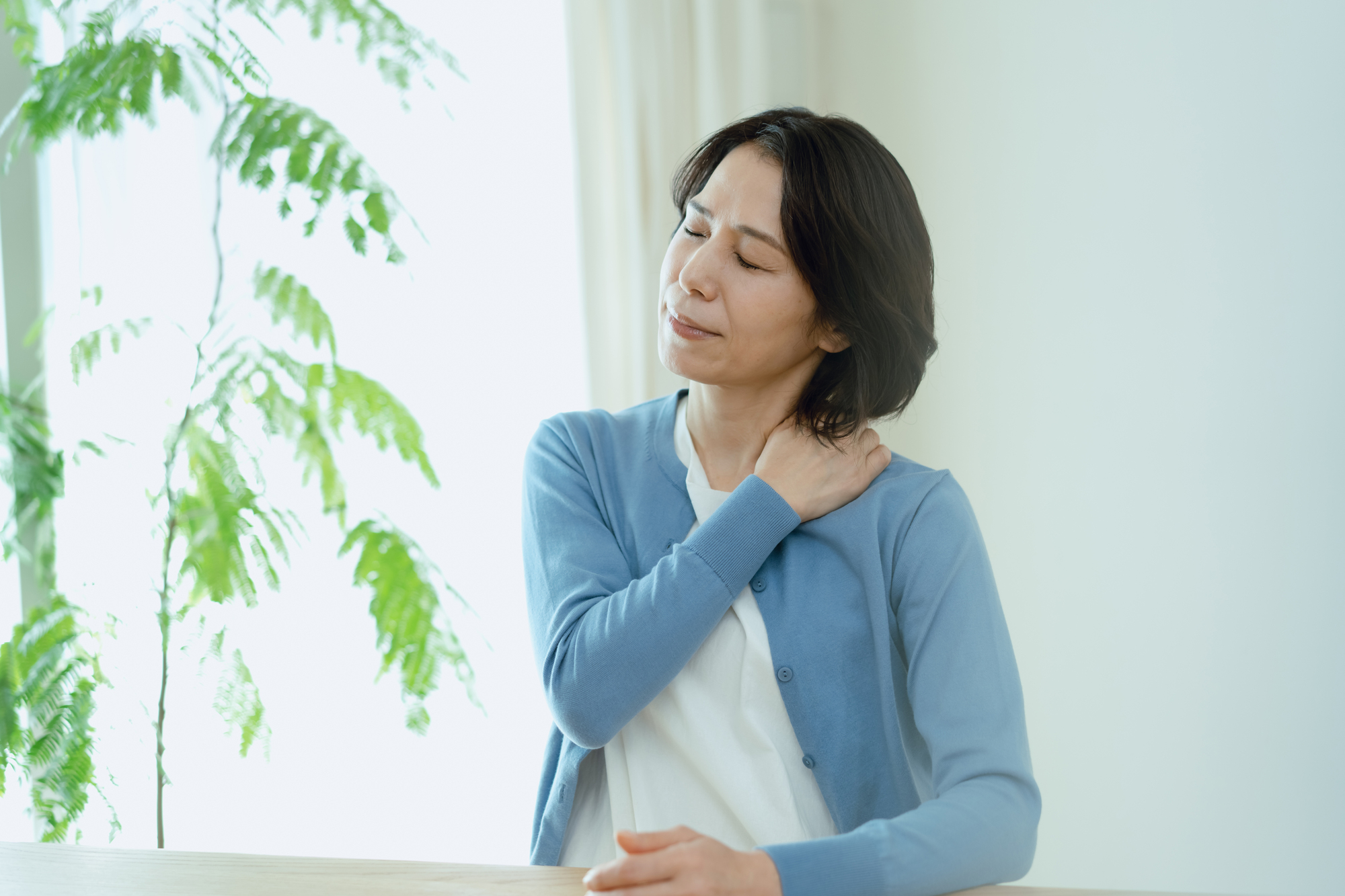 肩のこりに悩む女性