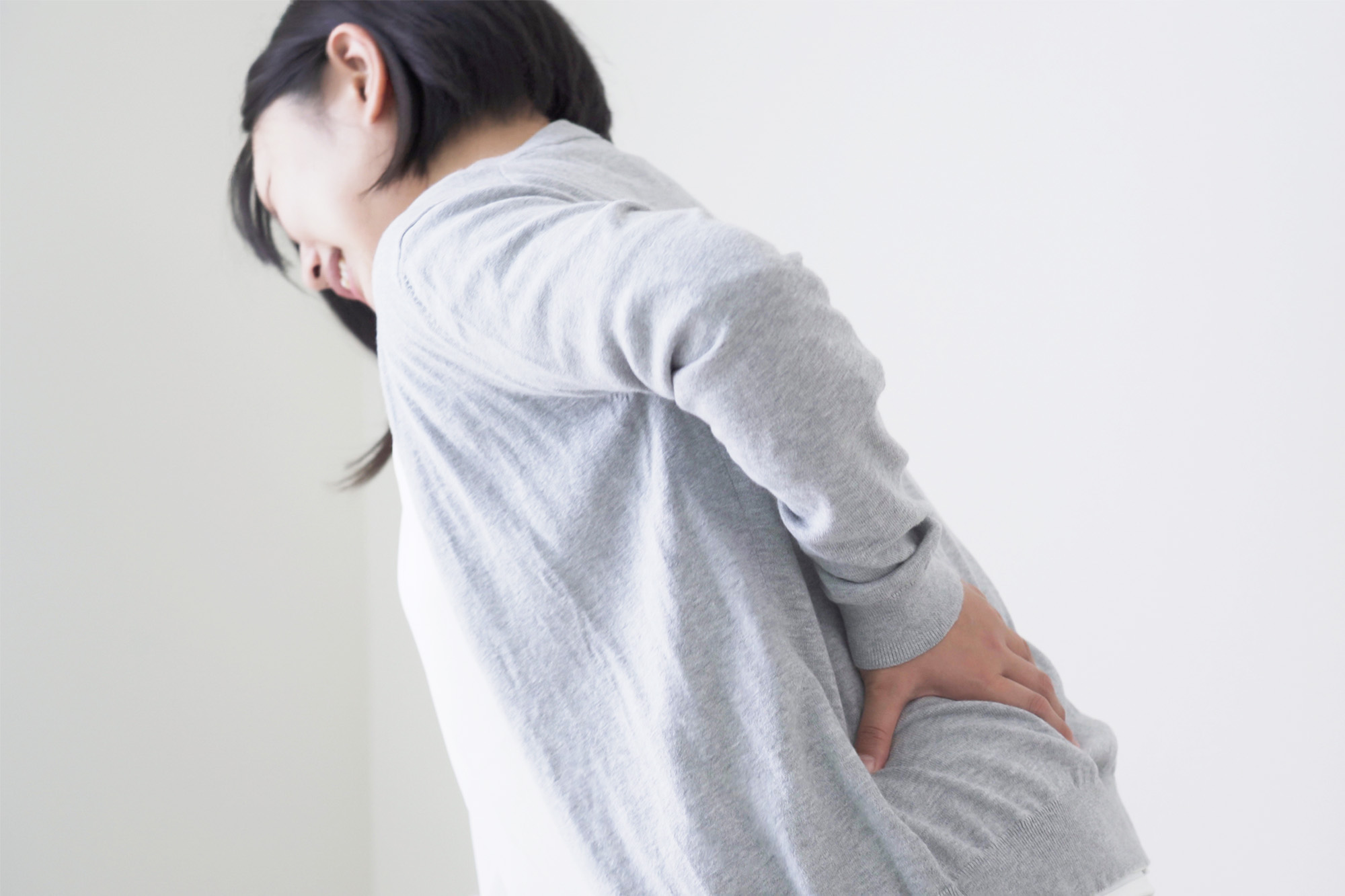 神経痛で腰を押さえる女性