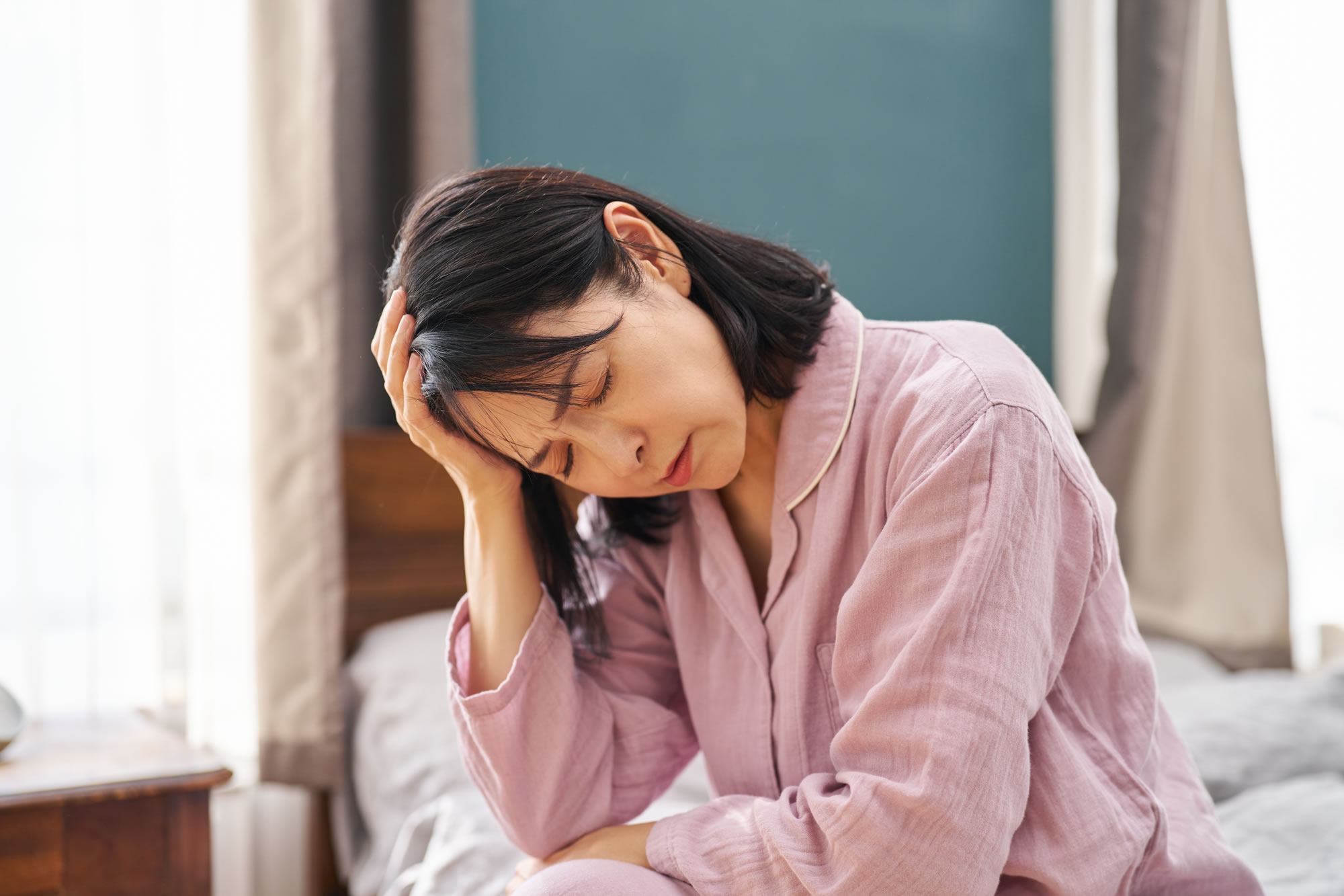 貧血で頭を抑える女性