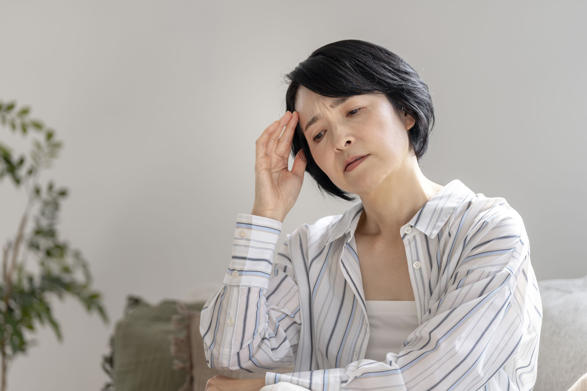 貧血で額に手を当てる女性