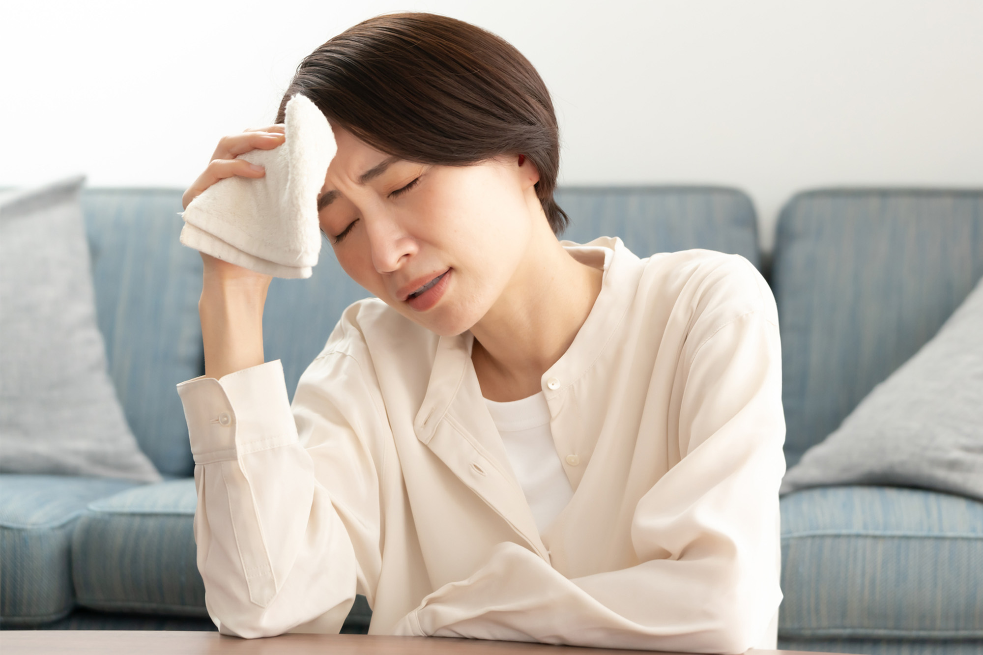 ホットフラッシュによる火照りで辛そうにする女性