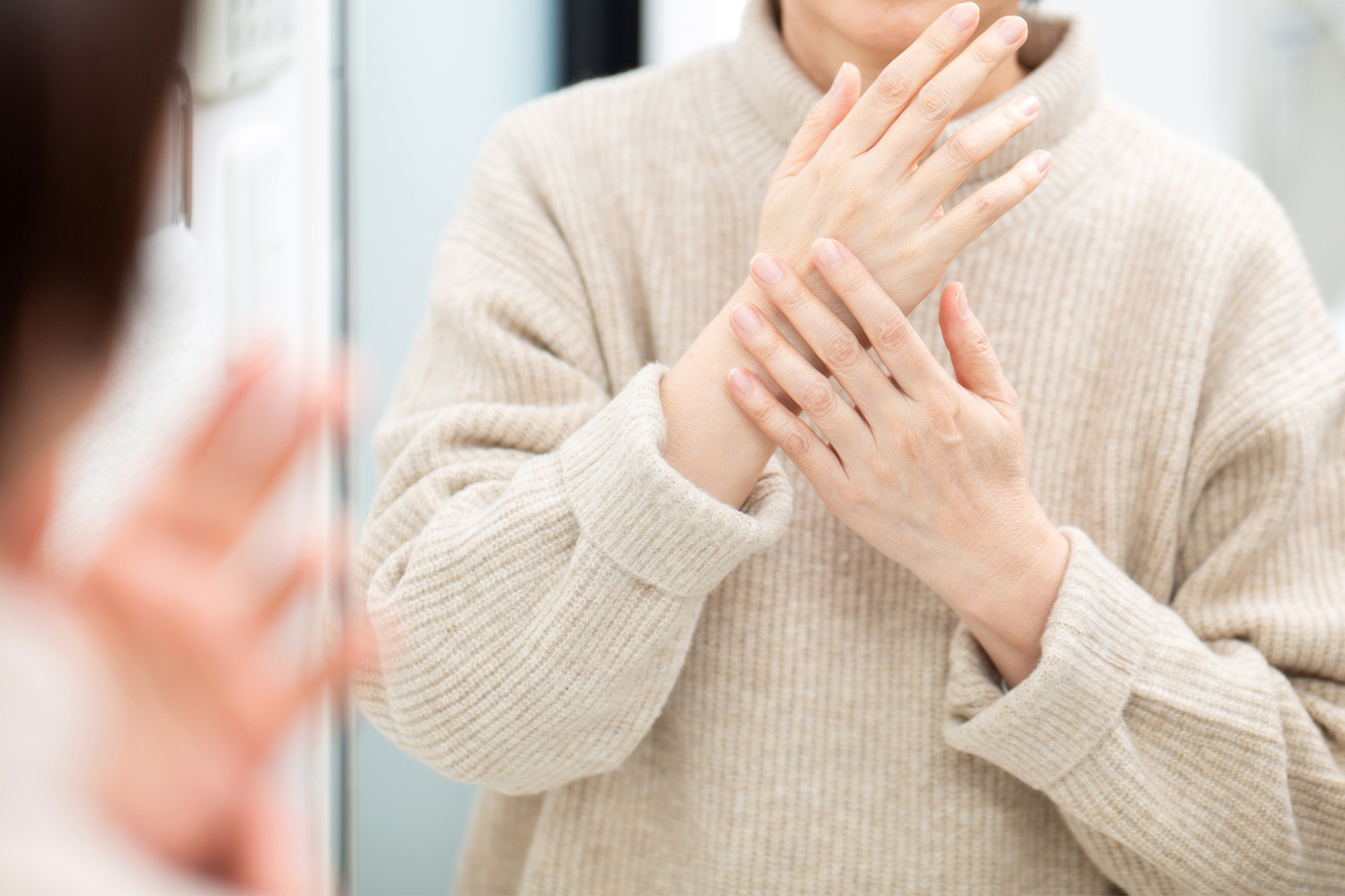 手のシミを気にする女性